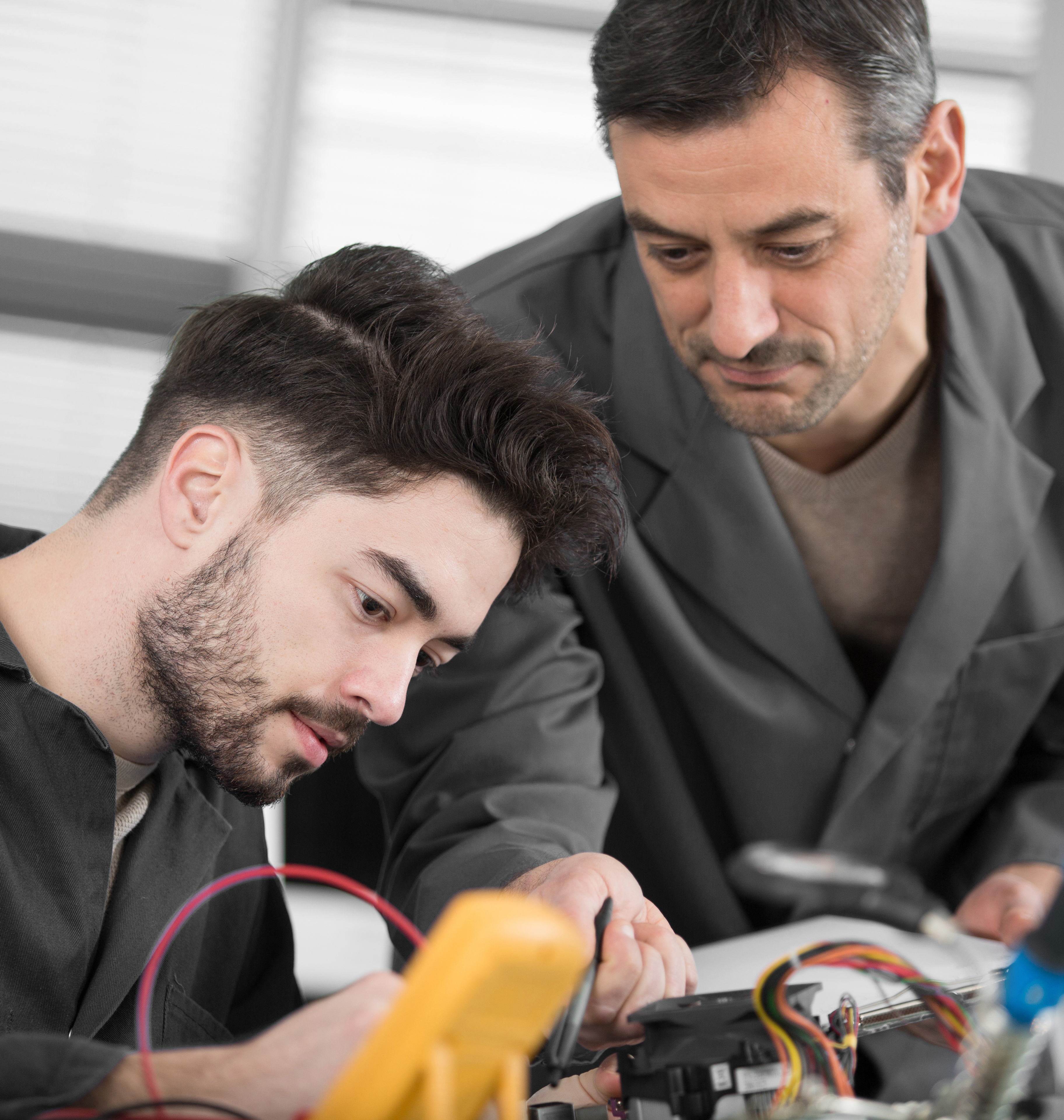 Kollege zeigt Auszubildenden Details bei der Arbeit